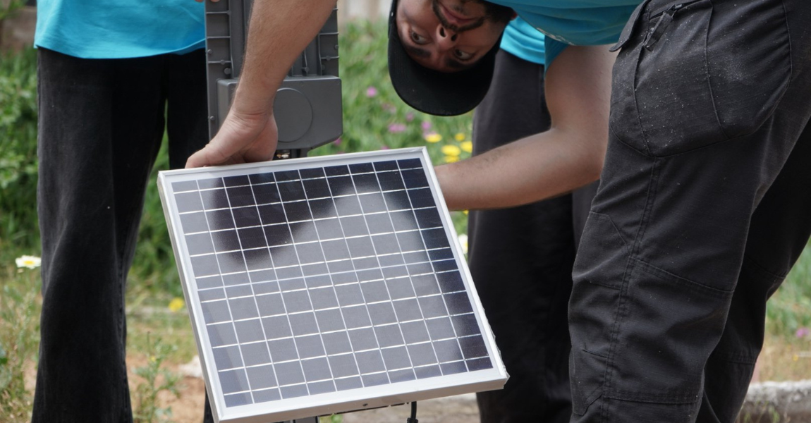 les bénévoles installent des panneaux solaires