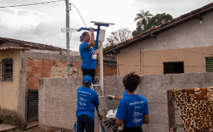 Volunteers from Litro de Luz and Nexans installing solar street lights