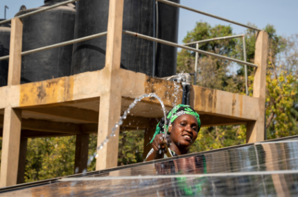 Femme maraîchère nettoyant les panneaux solaires à Casamance, Sénégal